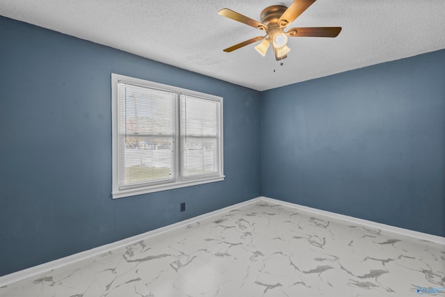 empty room with ceiling fan and a textured ceiling