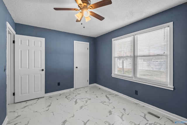 unfurnished bedroom featuring a textured ceiling, a closet, and ceiling fan