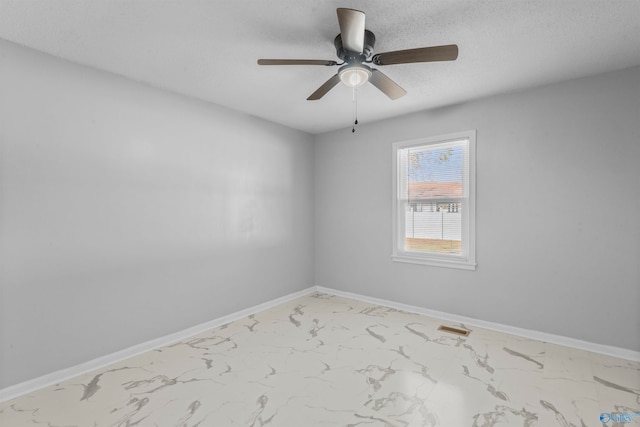 spare room featuring a textured ceiling and ceiling fan