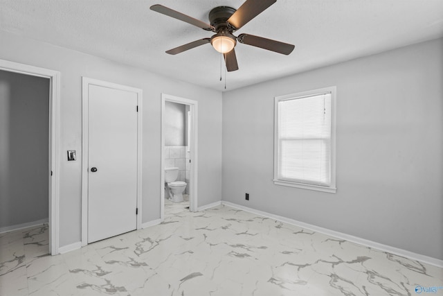 unfurnished bedroom featuring ensuite bathroom, ceiling fan, and a textured ceiling