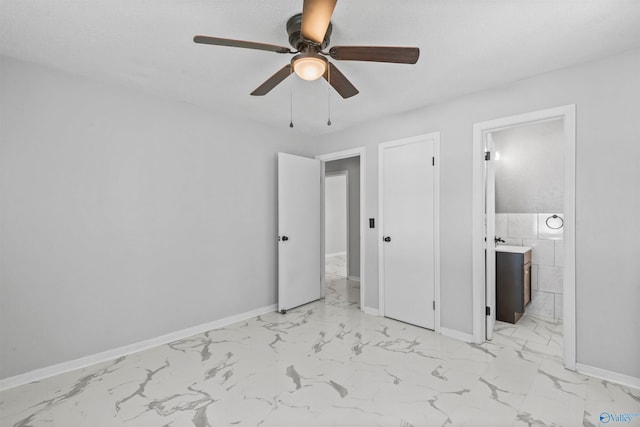 unfurnished bedroom featuring ensuite bathroom, ceiling fan, and tile walls