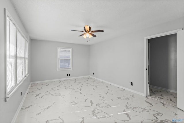 empty room with a textured ceiling and ceiling fan