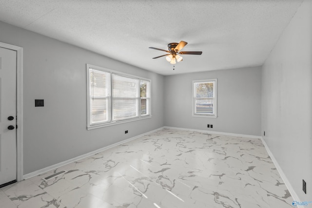 spare room featuring a textured ceiling and ceiling fan