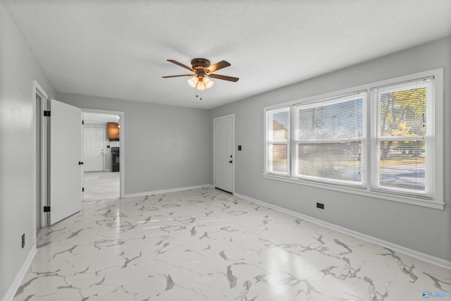 spare room featuring ceiling fan and a textured ceiling