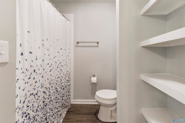 bathroom with hardwood / wood-style floors, toilet, and walk in shower