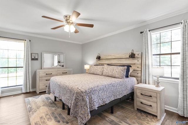 bedroom featuring dark hardwood / wood-style flooring, ceiling fan, and crown molding