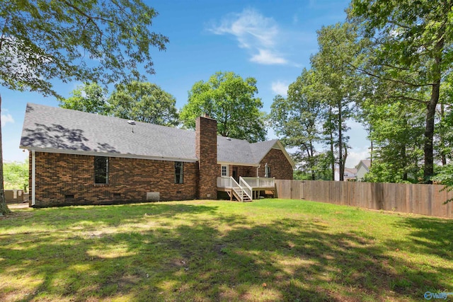 back of house featuring a deck and a yard