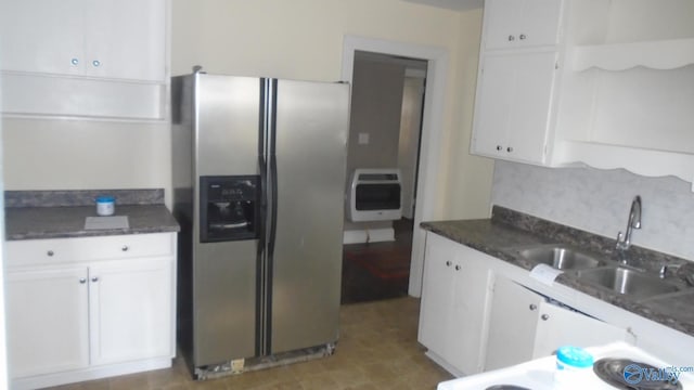 kitchen featuring heating unit, sink, white cabinets, dark stone counters, and stainless steel fridge with ice dispenser