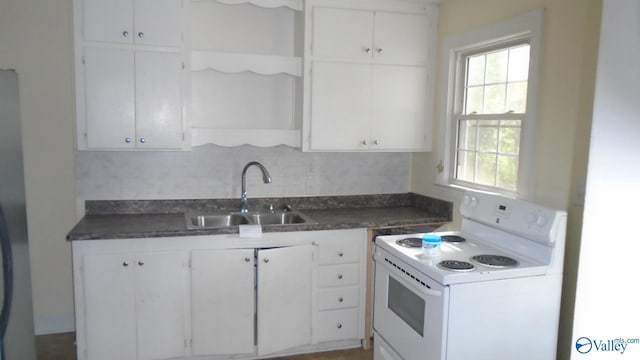 kitchen featuring backsplash, white range with electric cooktop, sink, and white cabinets