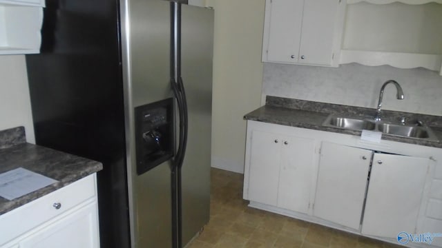 kitchen featuring backsplash, stainless steel fridge, sink, and white cabinets