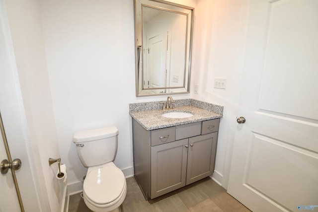 bathroom featuring tile patterned flooring, toilet, and vanity