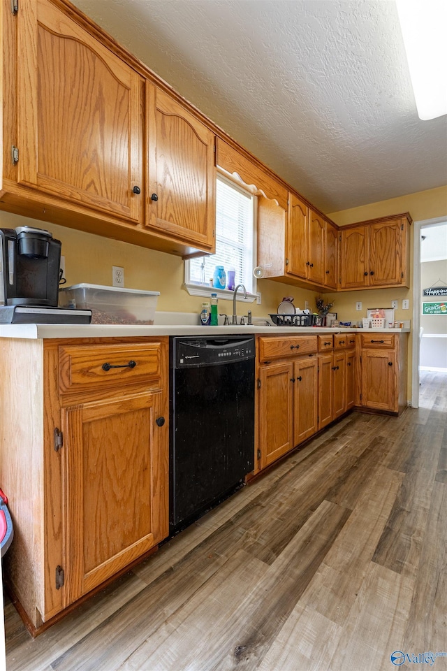 207 Sharp Dr, Gadsden, AL 35903 - kitchen with black dishwasher, wood finished floors, light countertops, brown cabinets, and a sink