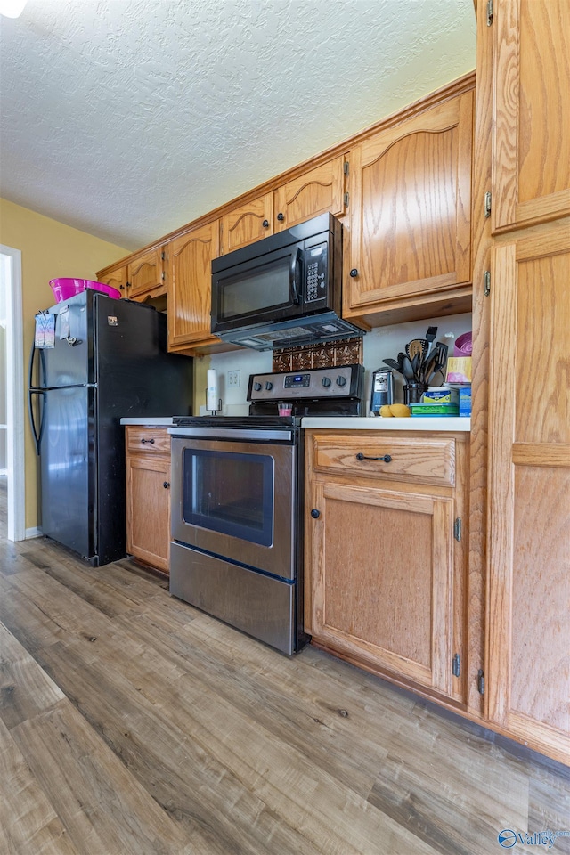 207 Sharp Dr, Gadsden, AL 35903 - kitchen with black appliances, light wood-style floors, and a textured ceiling