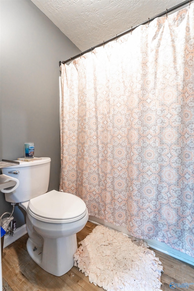 207 Sharp Dr, Gadsden, AL 35903 - full bathroom with baseboards, wood finished floors, toilet, a textured ceiling, and a shower with shower curtain