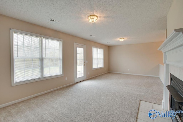 unfurnished living room featuring a textured ceiling and light colored carpet