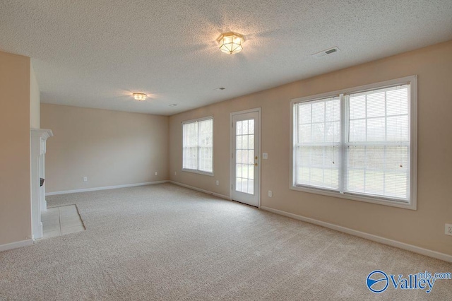 carpeted spare room featuring a textured ceiling