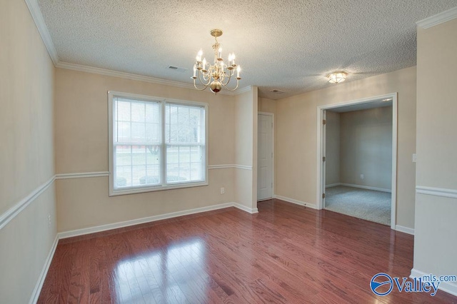 spare room with a textured ceiling, hardwood / wood-style floors, and a notable chandelier