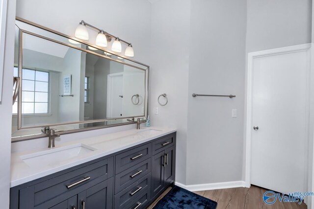 110 SW Cotton Bend Dr, Huntsville, AL 35824 - bathroom featuring wood finished floors, double vanity, and baseboards