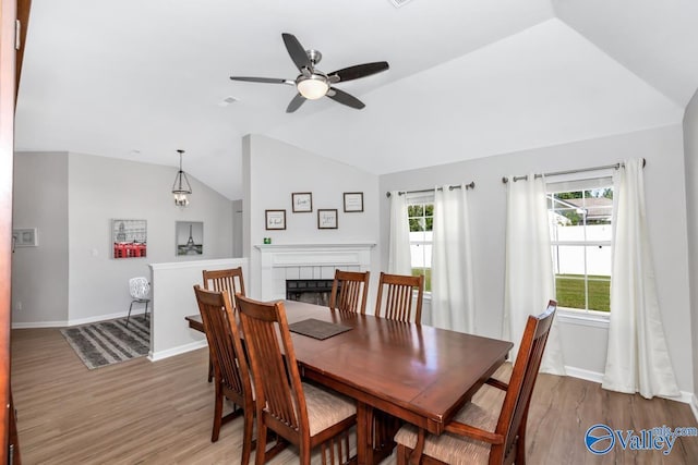110 SW Cotton Bend Dr, Huntsville, AL 35824 - dining area featuring vaulted ceiling, a ceiling fan, wood finished floors, baseboards, and a fireplace
