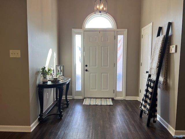 entryway with a chandelier, baseboards, and dark wood-style floors