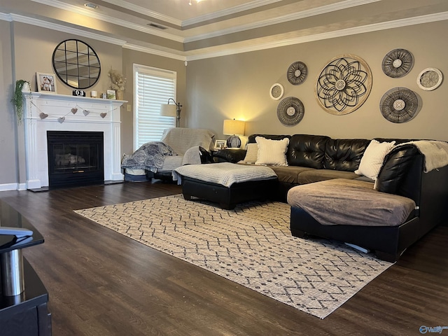 living room with visible vents, crown molding, a glass covered fireplace, and wood finished floors