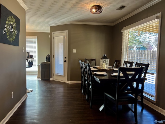 dining room featuring visible vents, baseboards, dark wood-style flooring, and ornamental molding