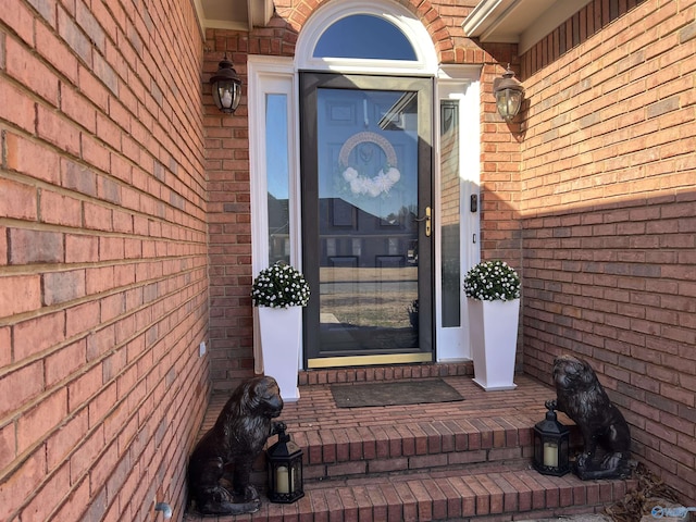 view of exterior entry featuring brick siding