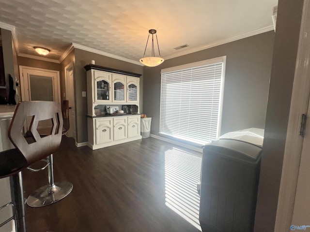 interior space with visible vents, baseboards, dark wood-style floors, and crown molding