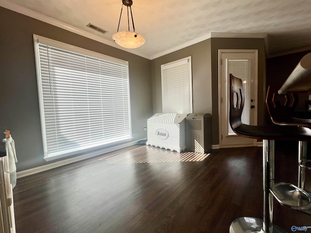 interior space featuring visible vents, baseboards, dark wood-style floors, and ornamental molding