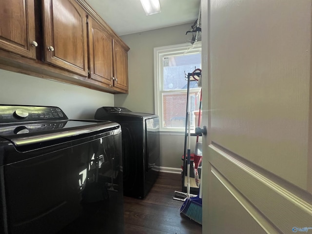 laundry area featuring baseboards, cabinet space, dark wood-style flooring, and washer and clothes dryer