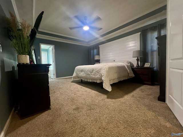 bedroom with a raised ceiling, a ceiling fan, carpet flooring, crown molding, and baseboards