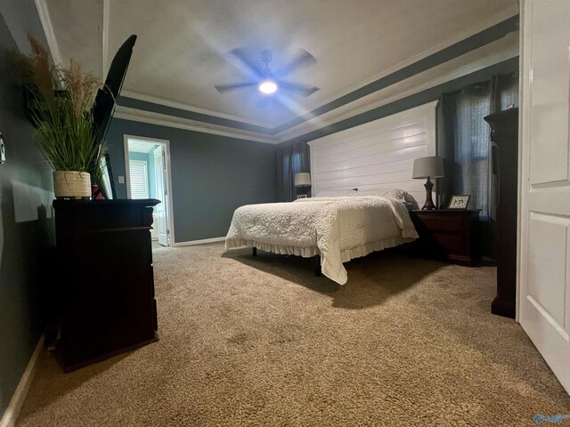 carpeted bedroom featuring baseboards, a raised ceiling, ornamental molding, and a ceiling fan