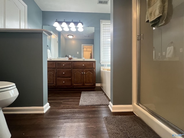 bathroom featuring a shower stall, a garden tub, wood finished floors, and baseboards