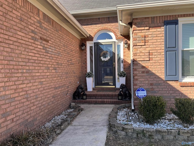 entrance to property with brick siding and roof with shingles