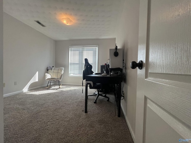 carpeted home office featuring visible vents and baseboards