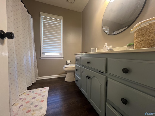 full bathroom with vanity, a shower with curtain, wood finished floors, baseboards, and toilet