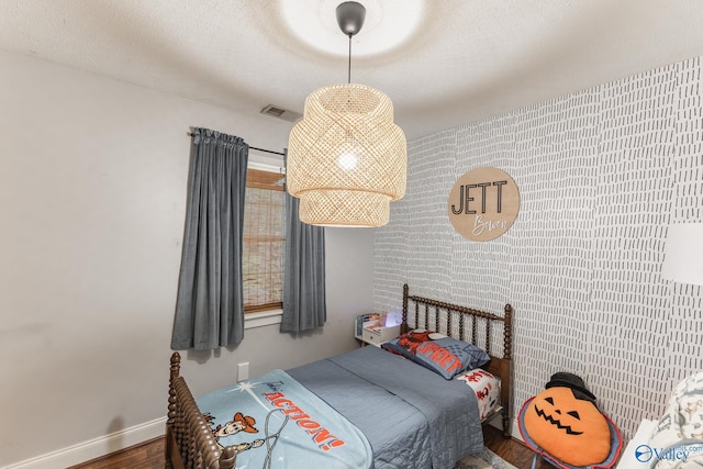 3516 Oleander Rd SW, Huntsville, AL 35805 - bedroom featuring baseboards, a textured ceiling, wood finished floors, and visible vents
