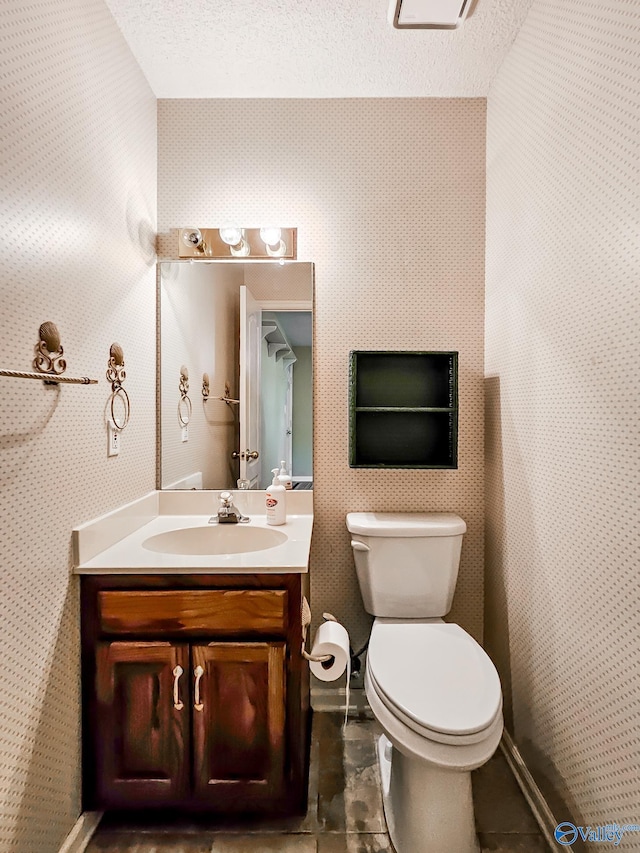 bathroom featuring tile patterned floors, a textured ceiling, vanity, and toilet