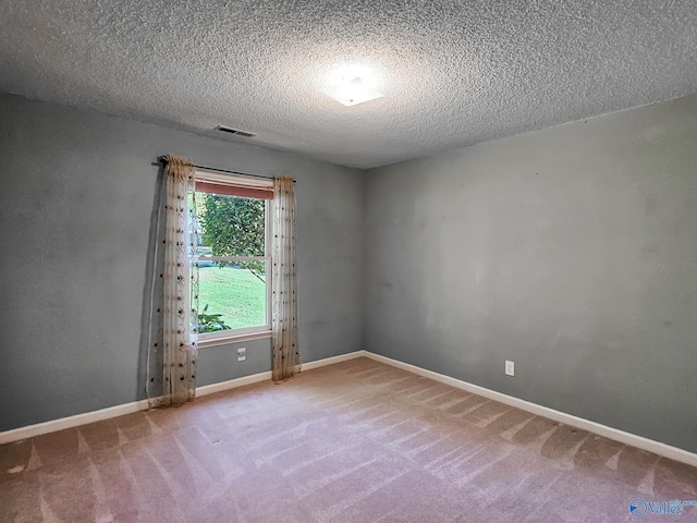 empty room featuring a textured ceiling and carpet