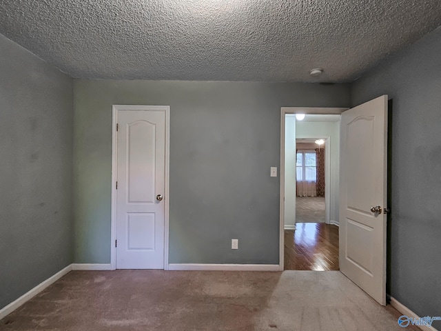 unfurnished bedroom featuring light carpet and a textured ceiling