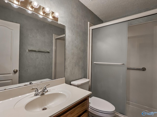 bathroom featuring vanity, a textured ceiling, an enclosed shower, and toilet