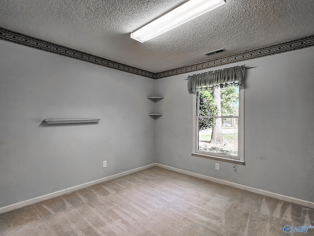 carpeted empty room featuring a textured ceiling