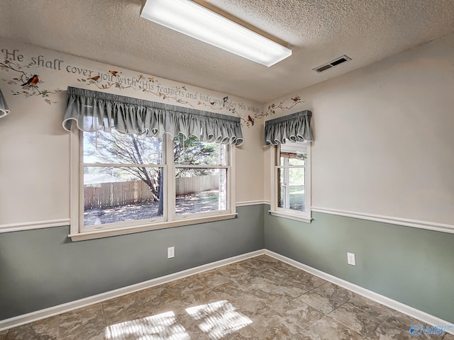 spare room with a textured ceiling