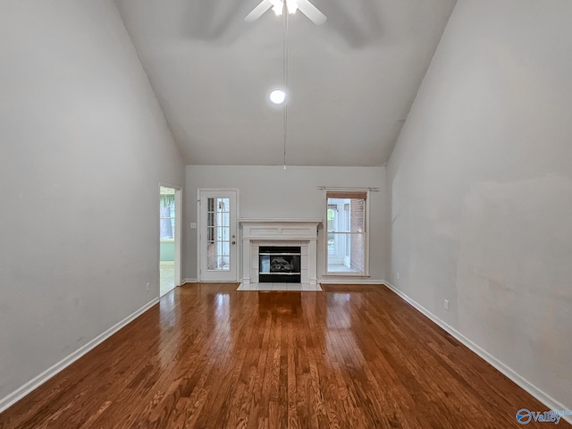 unfurnished living room with ceiling fan, a tile fireplace, hardwood / wood-style flooring, and a healthy amount of sunlight