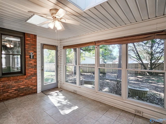 unfurnished sunroom featuring ceiling fan and a skylight