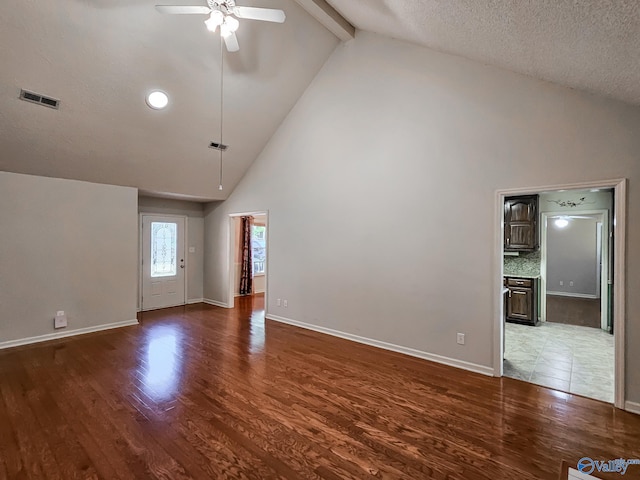 interior space with a textured ceiling, dark hardwood / wood-style floors, beam ceiling, high vaulted ceiling, and ceiling fan