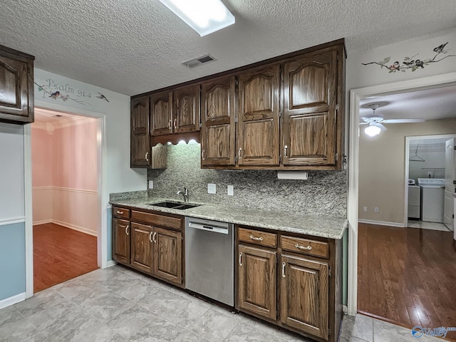 kitchen featuring decorative backsplash, independent washer and dryer, dishwasher, ceiling fan, and light hardwood / wood-style flooring