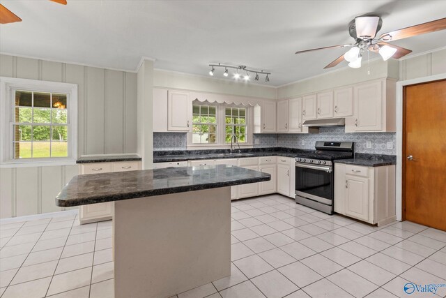 kitchen with stainless steel range with gas cooktop, white cabinetry, and decorative backsplash