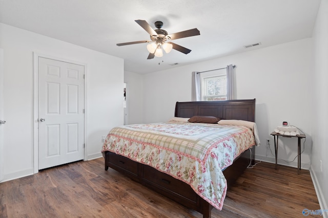 bedroom with dark hardwood / wood-style flooring and ceiling fan