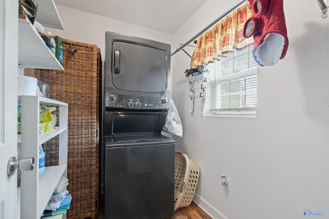 laundry room with hardwood / wood-style floors and stacked washer and clothes dryer